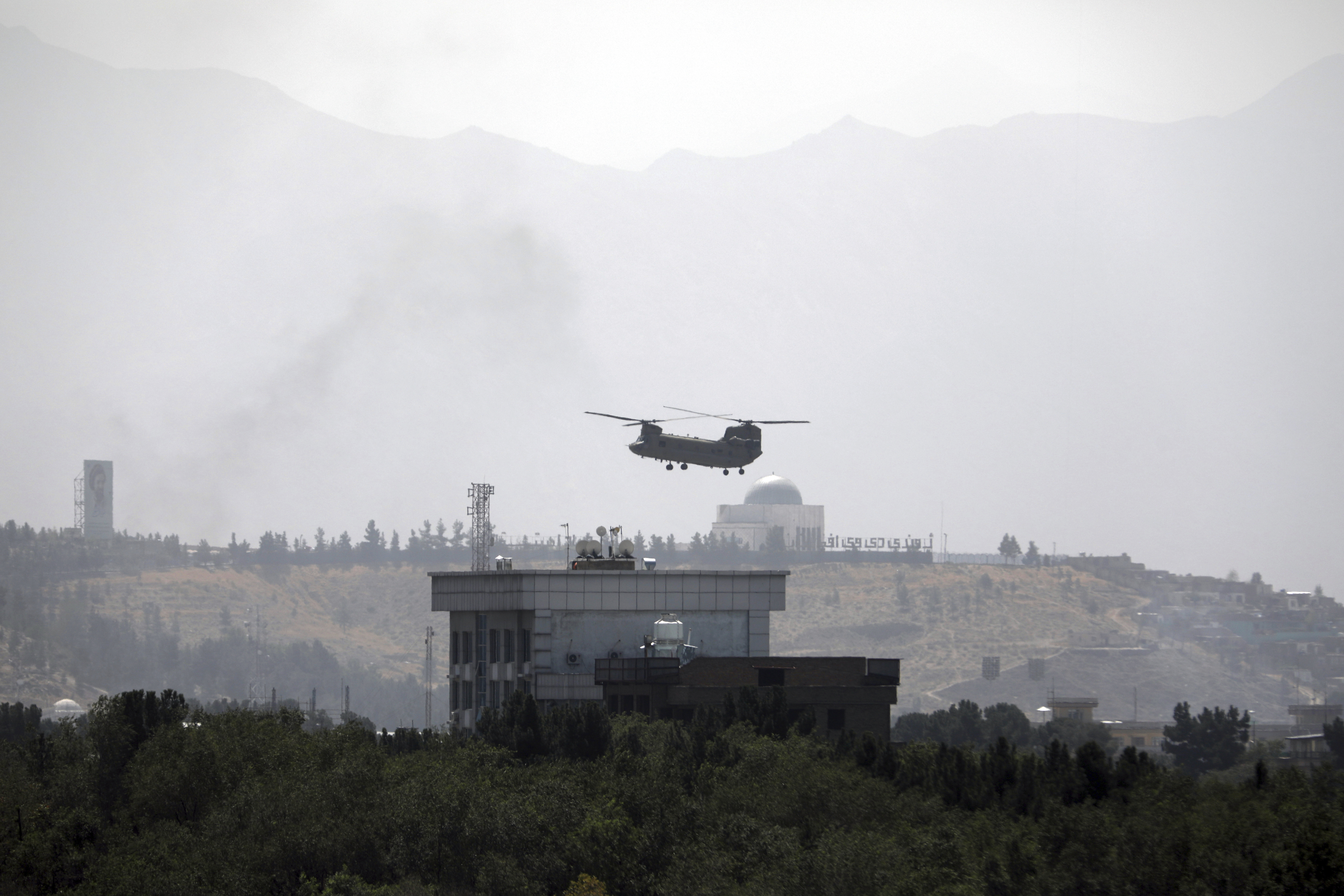 A helicopter flying over a city in Afghanistan mountains